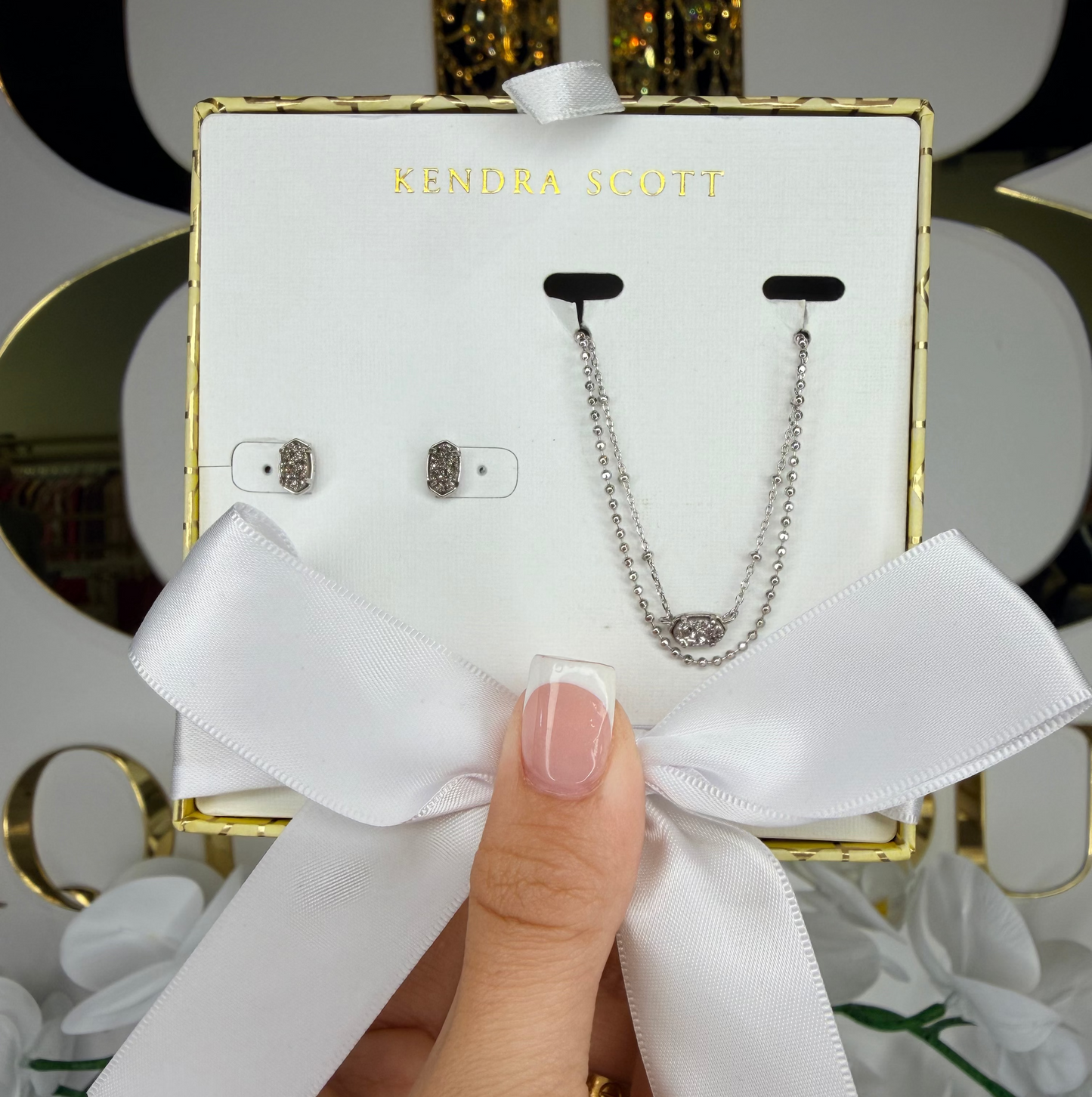 Hand holding silver pendant Kendra Scott gift set 
