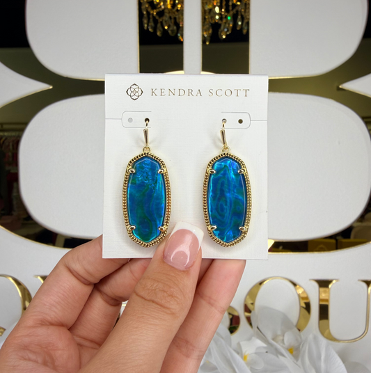 Kendra Scott earrings in front of bb with blue stone 