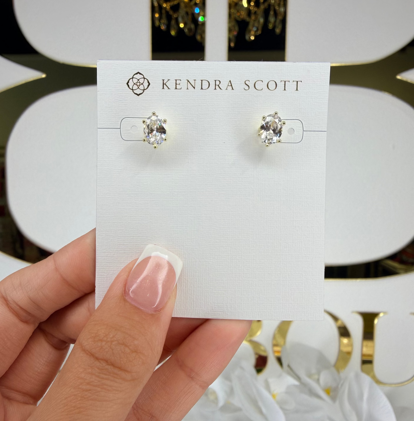 Hand holding diamond Kendra Scott studs 