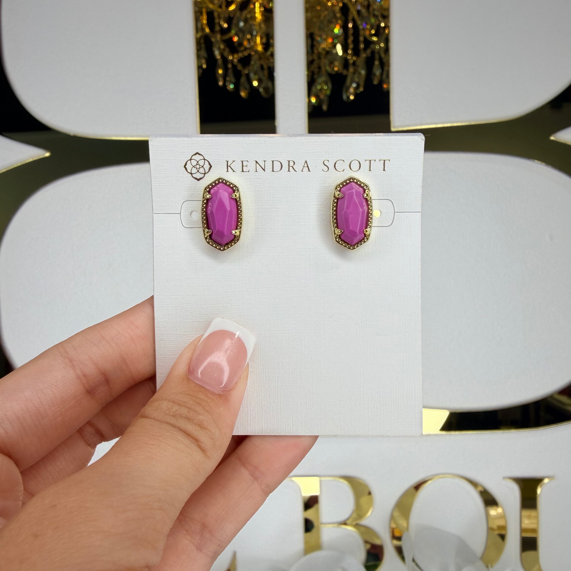 Kendra Scott earrings with pink gemstones held on a branded card.