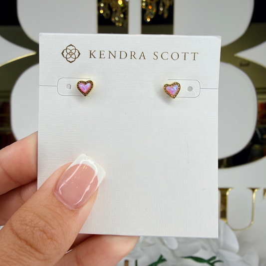 Kendra Scott earrings on a card held by a hand with a decorative background