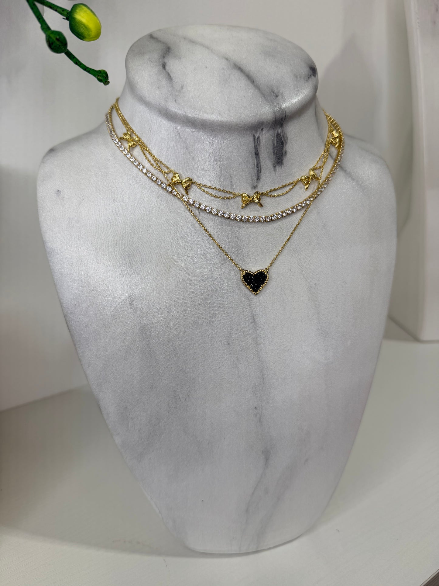 Gold necklaces on a marble bust