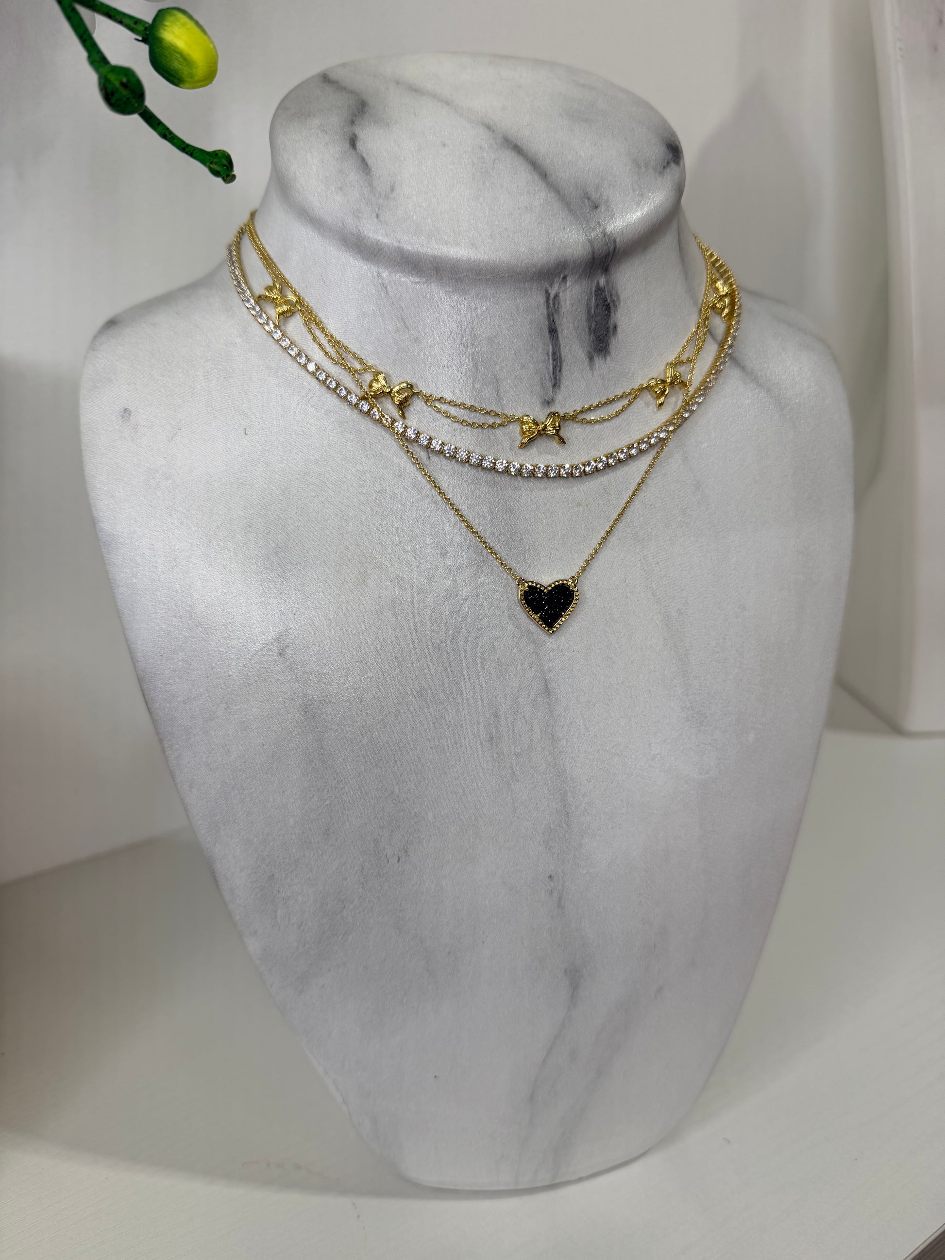 Gold necklaces on a marble bust