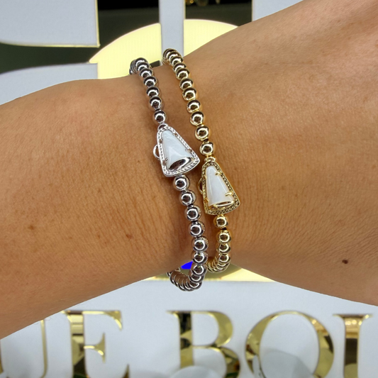 Bracelet with elephant charm on wrist against a decorative background