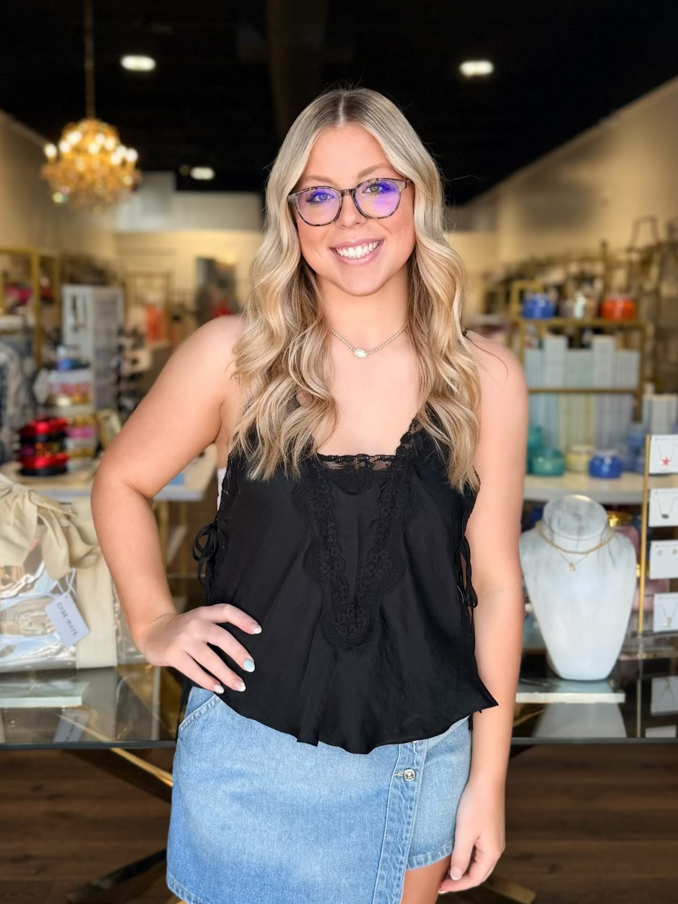 model wearing black lace top with denim skirt