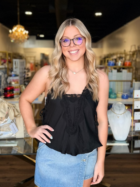 model wearing black lace top with denim skirt