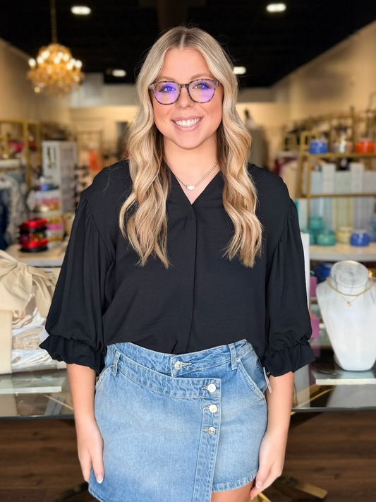 model wearing black dress top with denim skirt