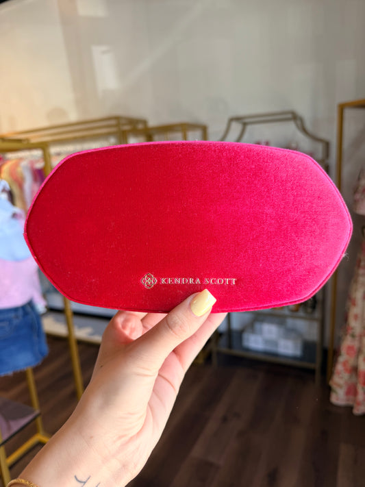 Kendra Scott jewelry box in hot pink in front of store 