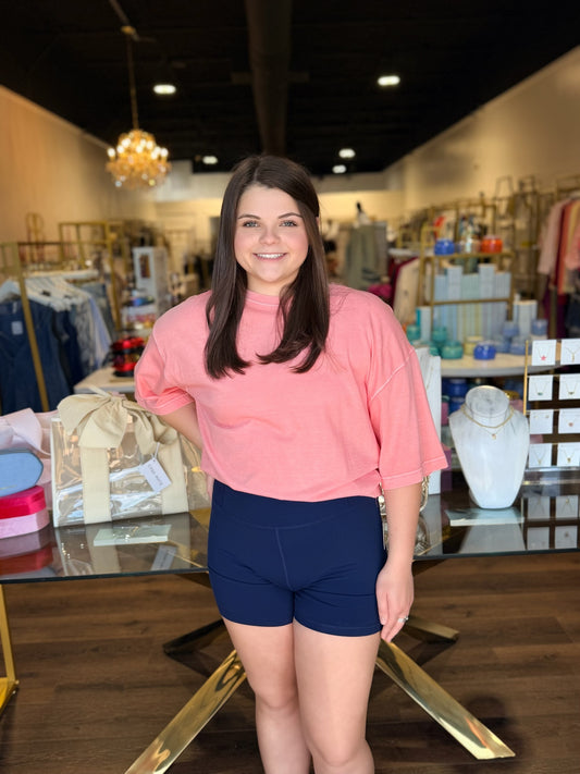 Model standing infront of store in oversized tee and navy biker shorts 
