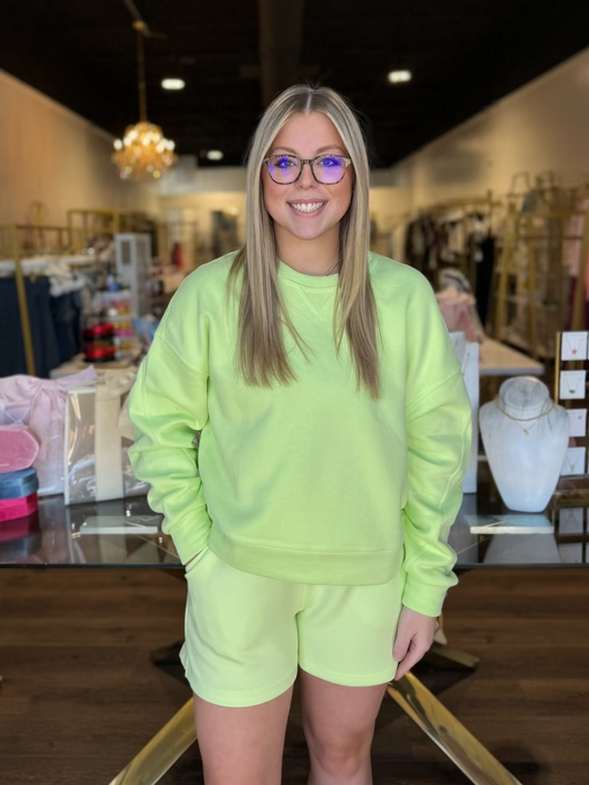 model wearing yellow green sweatshirt and shorts