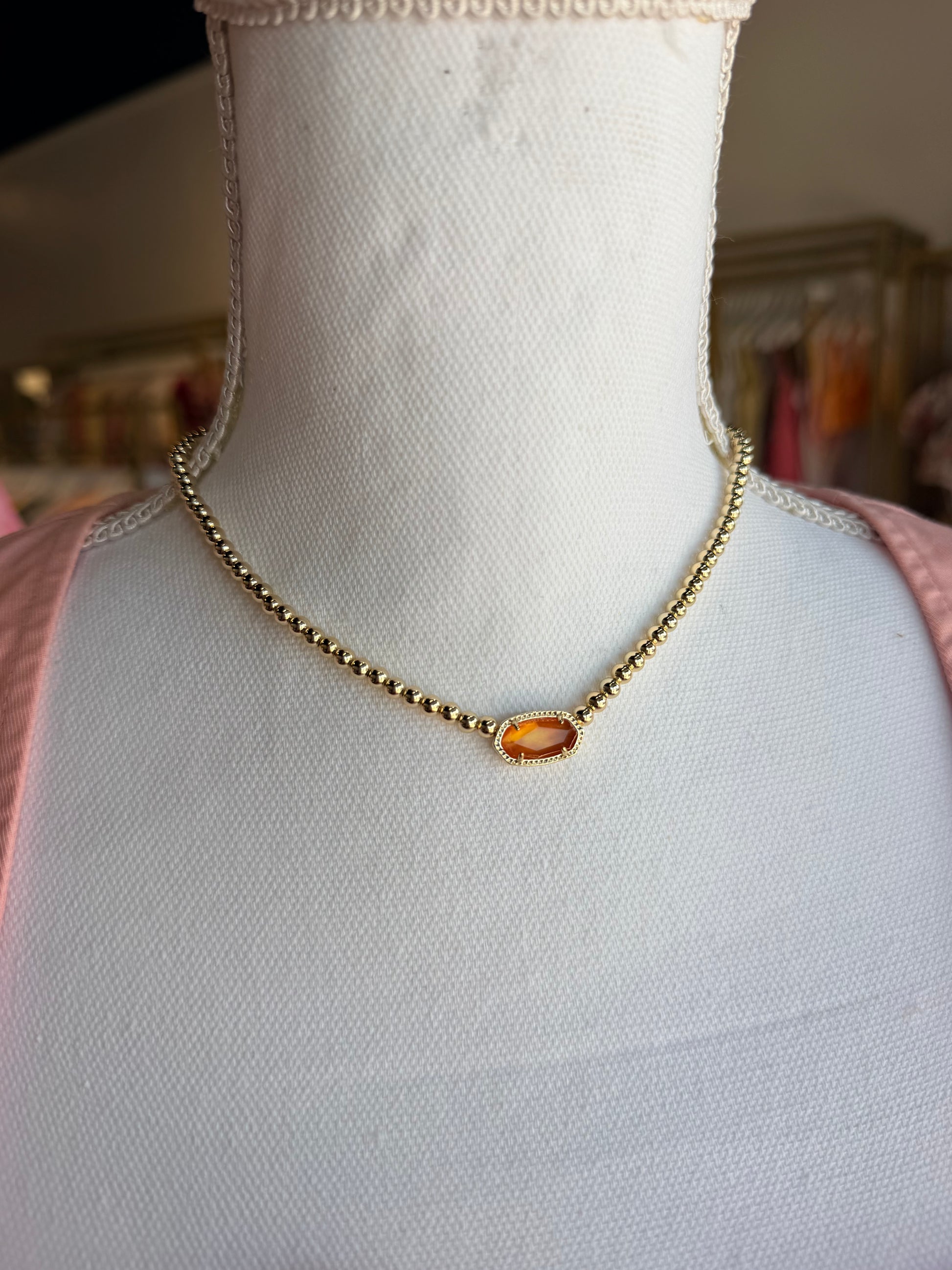 Kendra Scott gold beaded necklace with orange stone