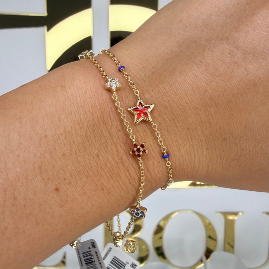 Gold bracelet with star charm on a wrist, blurred background with 'Boulevard' branding.