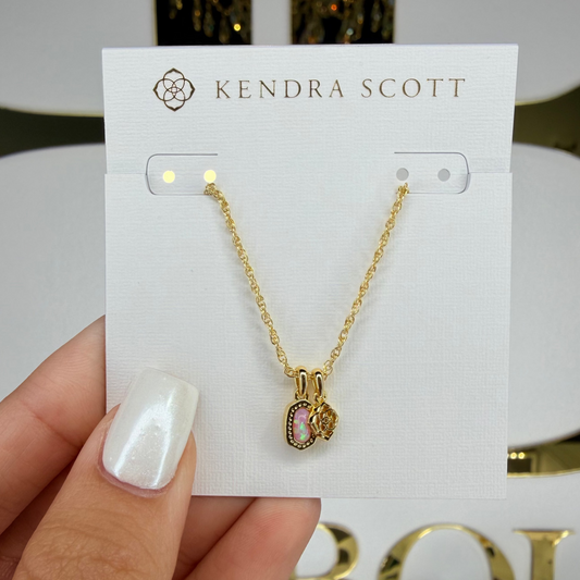 Gold necklace on a Kendra Scott card held by a hand with white nail polish.