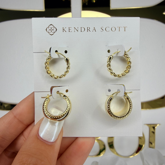 Gold hoop earrings on a Kendra Scott card held by a hand.

