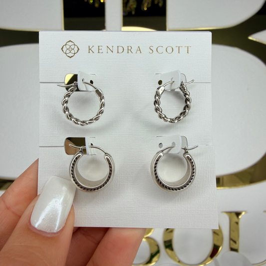 Set of silver hoop earrings on a Kendra Scott card held by a hand.