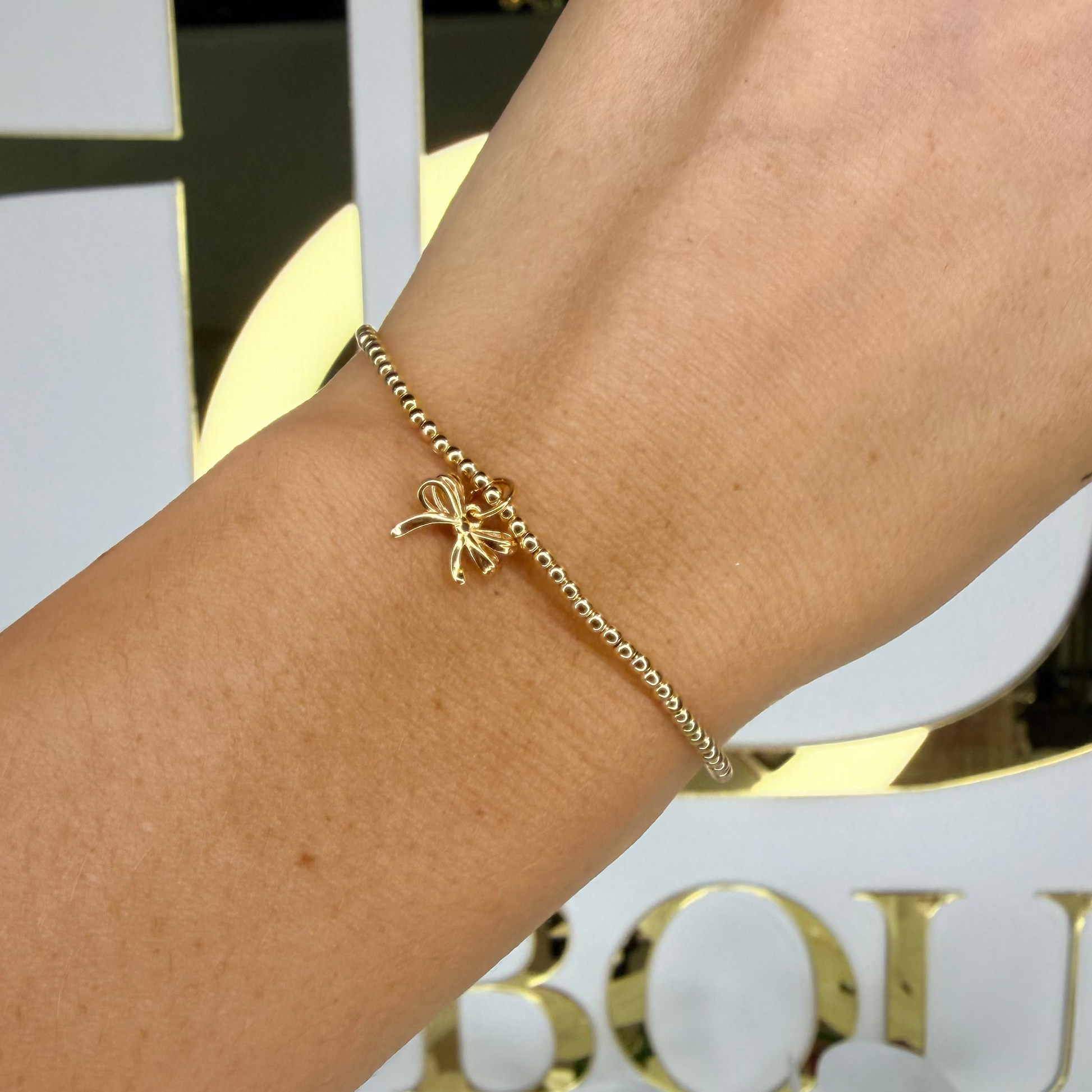 Gold bracelet on a wrist with a blurred background