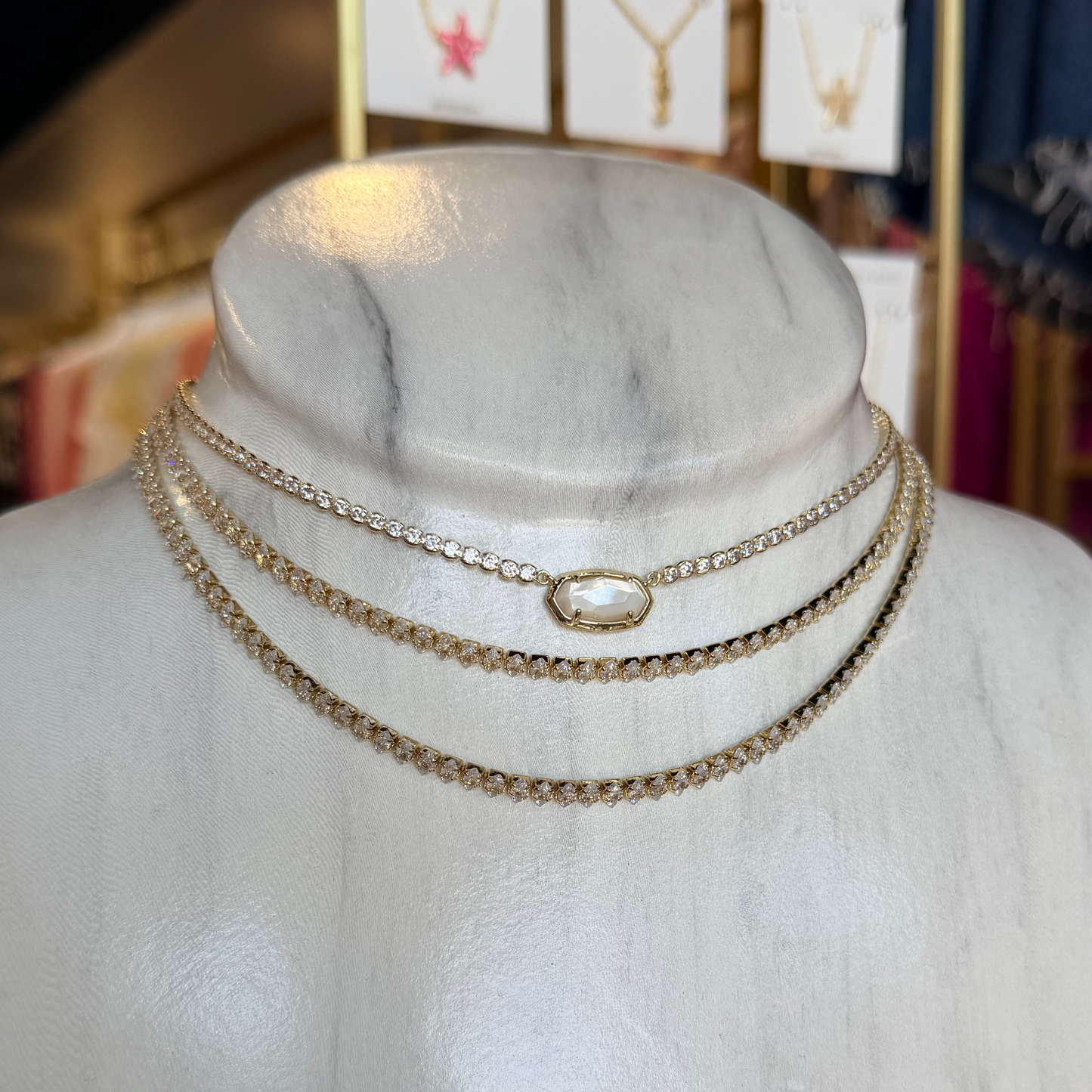 Gold necklace on a mannequin bust with a blurred store background