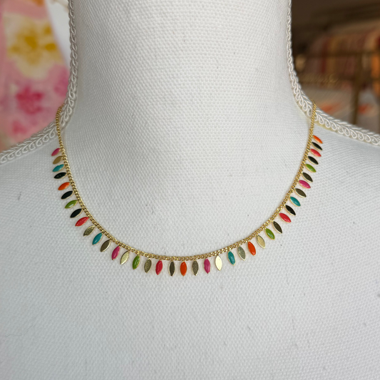 Colorful beaded necklace on a mannequin with a blurred background.