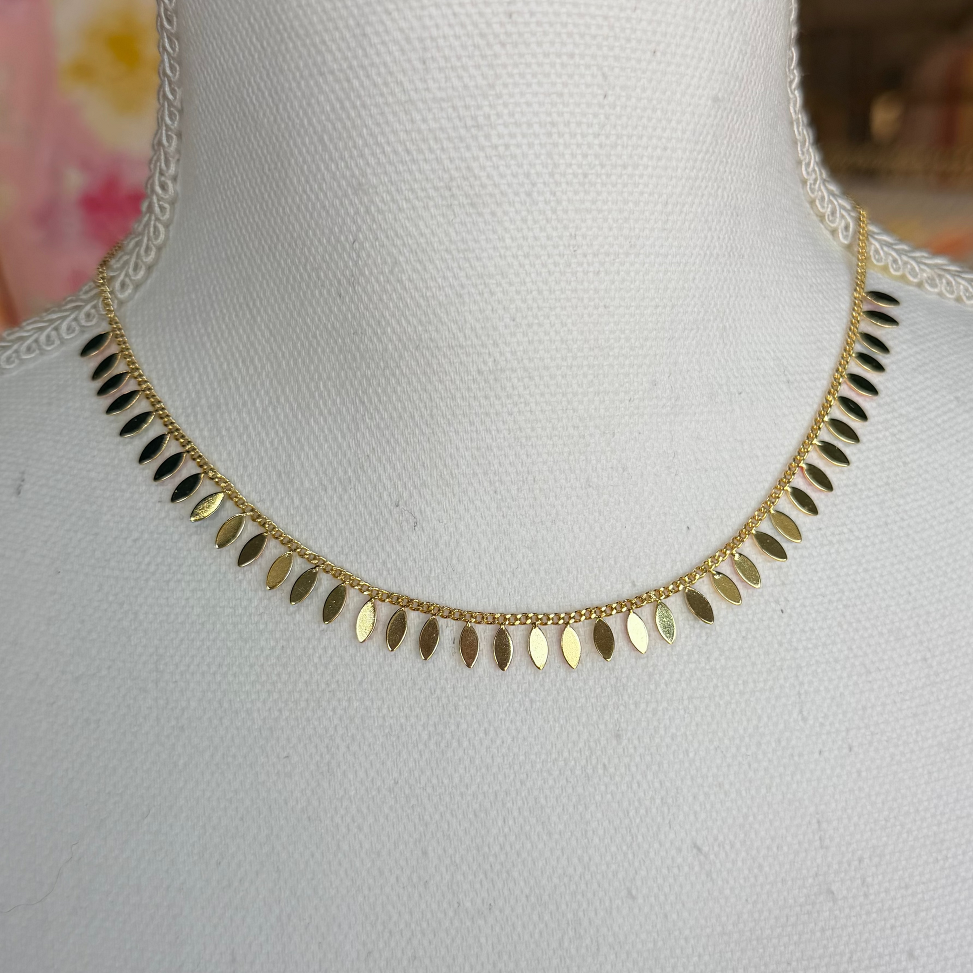 Gold necklace on a mannequin with a blurred background