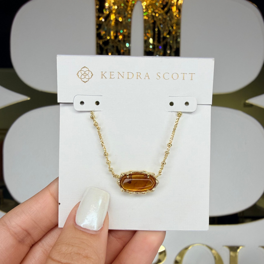 Kendra Scott gold bamboo necklace infront of bb 