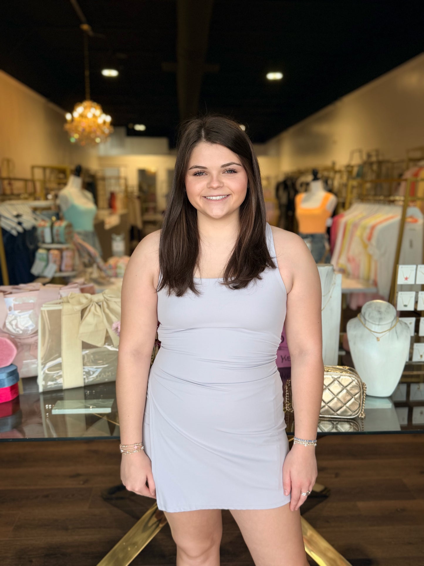 Model standing in front of store with purple never better dress 