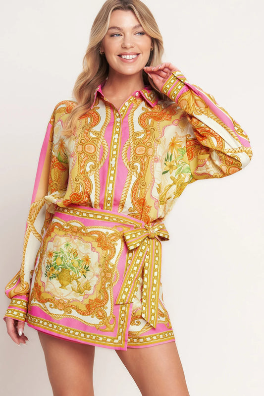 Woman wearing a colorful patterned dress on a plain background