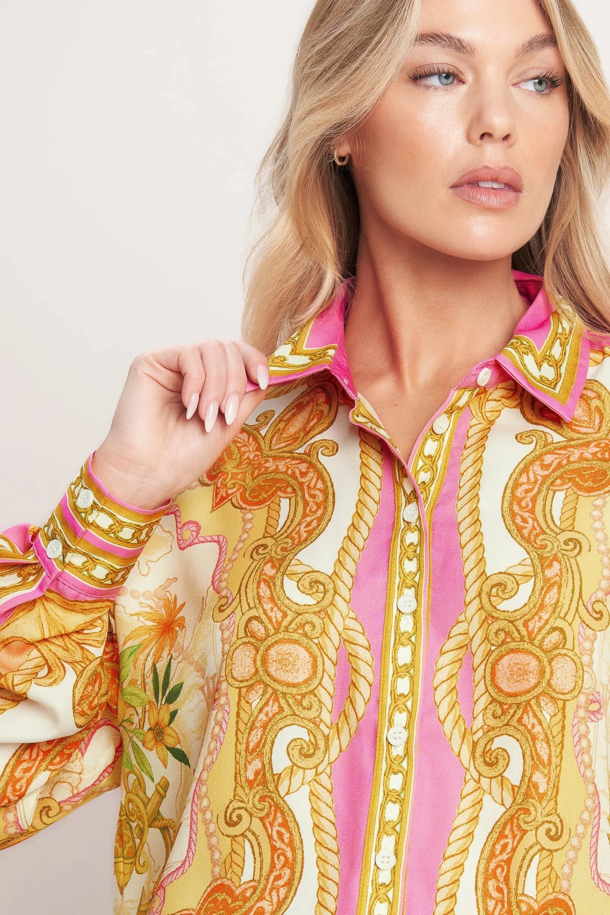 Woman wearing a colorful patterned shirt with a plain background