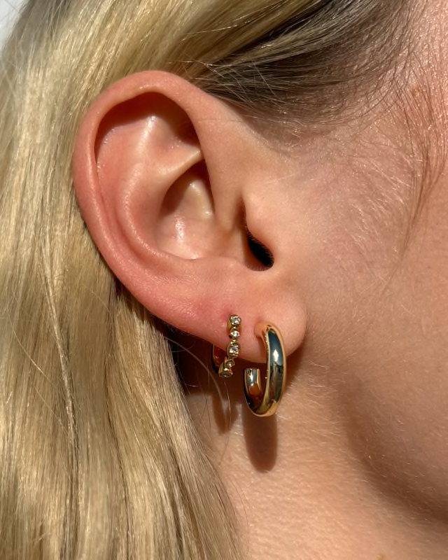 BOUTIQUE KENDRA SCOTT COLETTE GOLD HUGGIE EARRINGS IN EAR