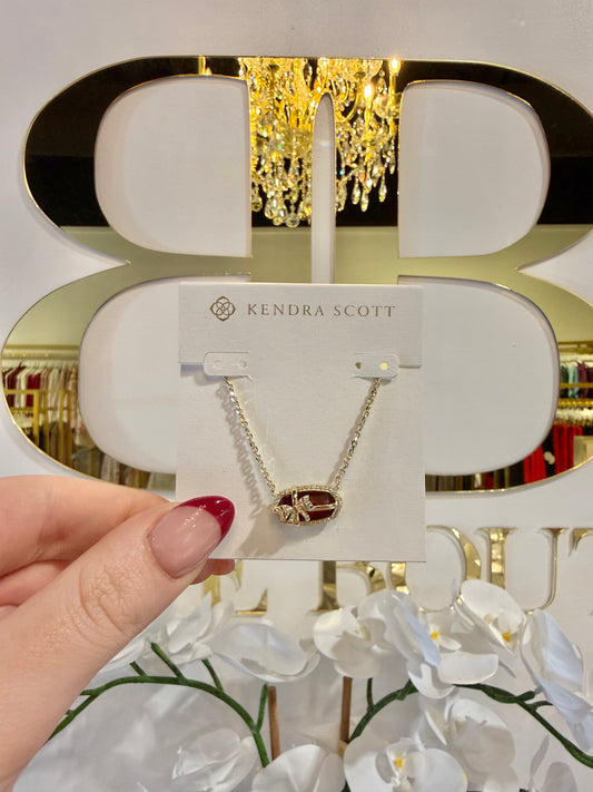 BOUTIQUE KENDRA SCOTT ELISA BOW GOLD SHORT PENDANT NECKLACE IN DARK BURGUNDY ILLUSION IN HAND
