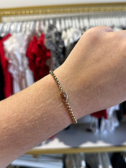 BOUTIQUE KENDRA SCOTT FOOTBALL GOLD STRETCH BRACELET IN ORANGE GOLSTONE ON ARM