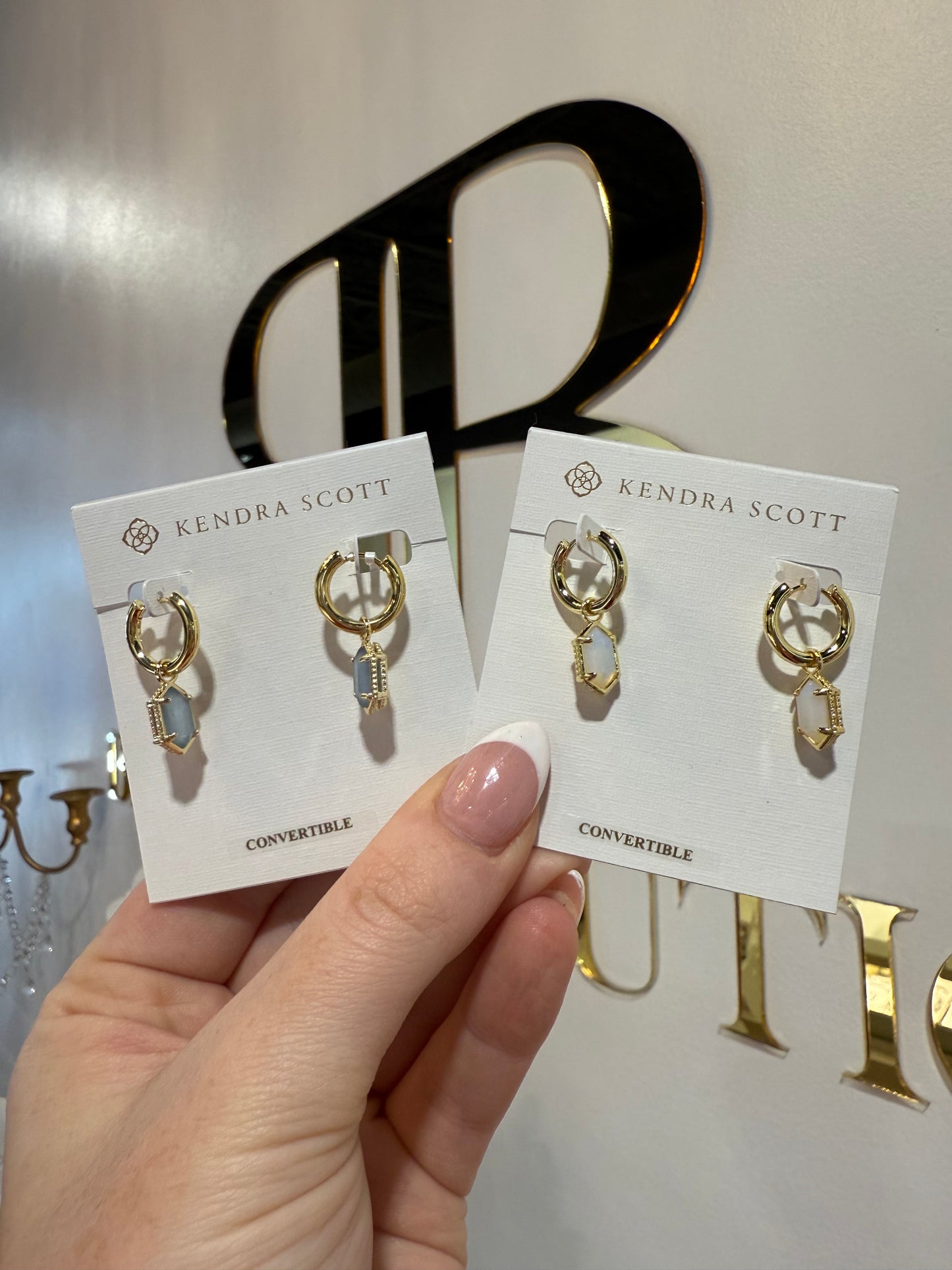 BOUTIQUE KENDRA SCOTT GOLD HALLIE HUGGIE EARRINGS IN HAND