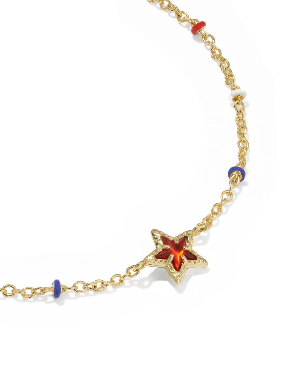 Gold bracelet with a star-shaped clasp featuring red and blue stones on a white background