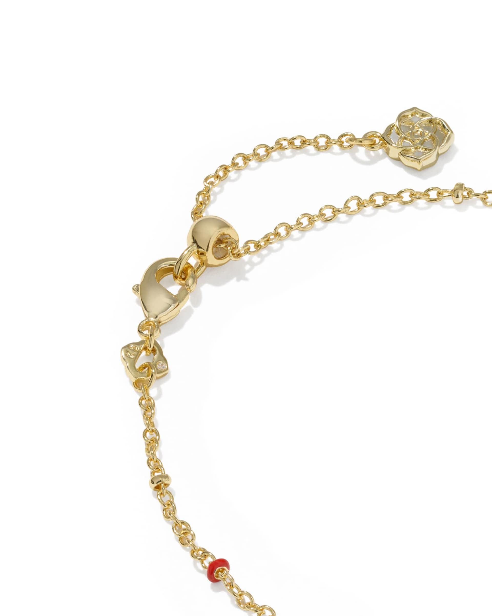 Gold chain bracelet with round pendants on a white background