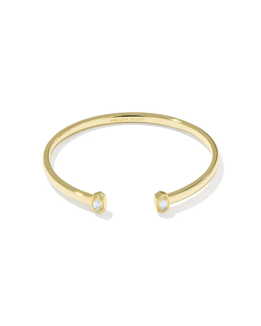 A gold open cuff bracelet by Sandra Scott, featuring two small oval bezel-set white stones at the ends, shown on a clean white background.