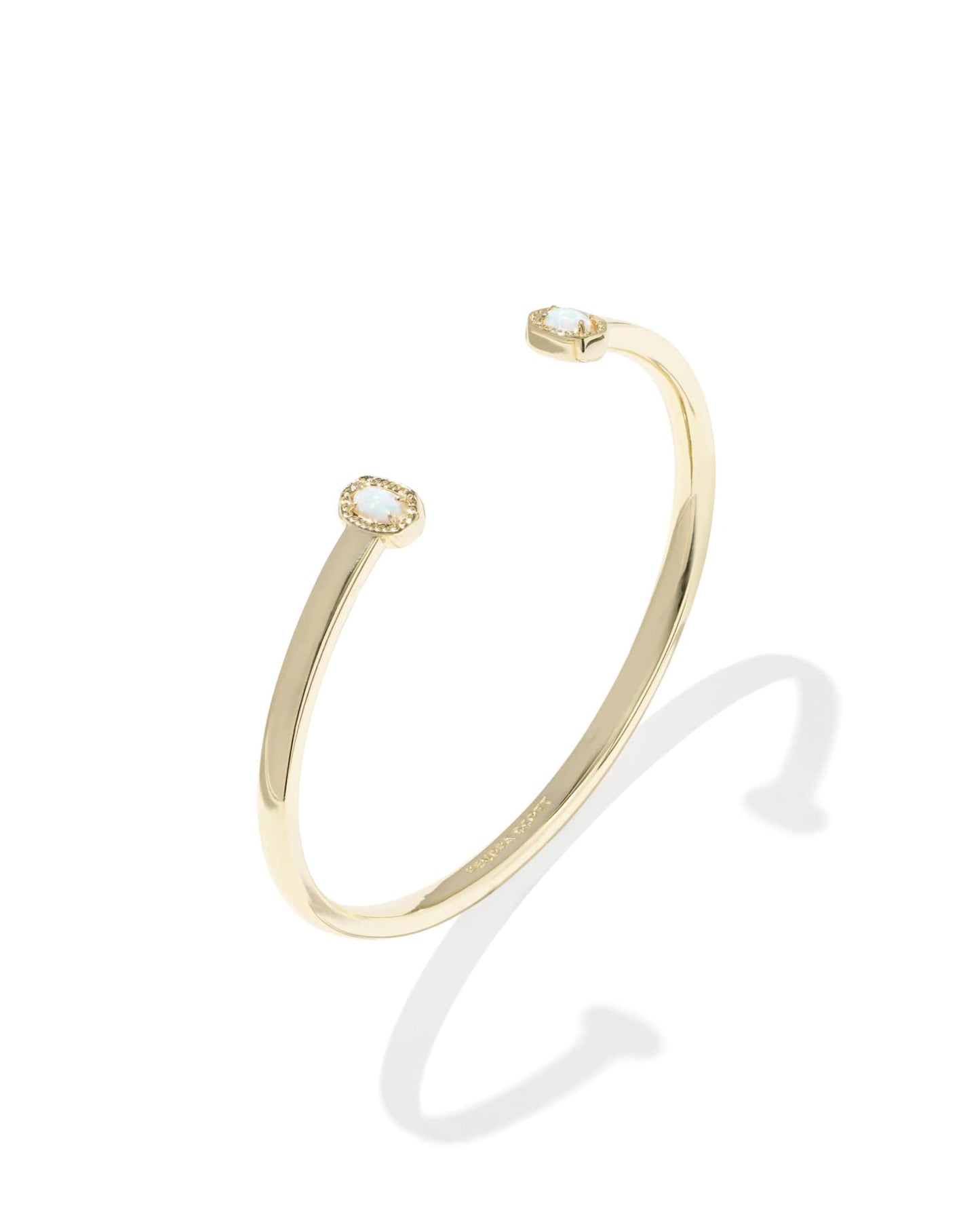 Gold bracelet with a small round embellishment on a white background