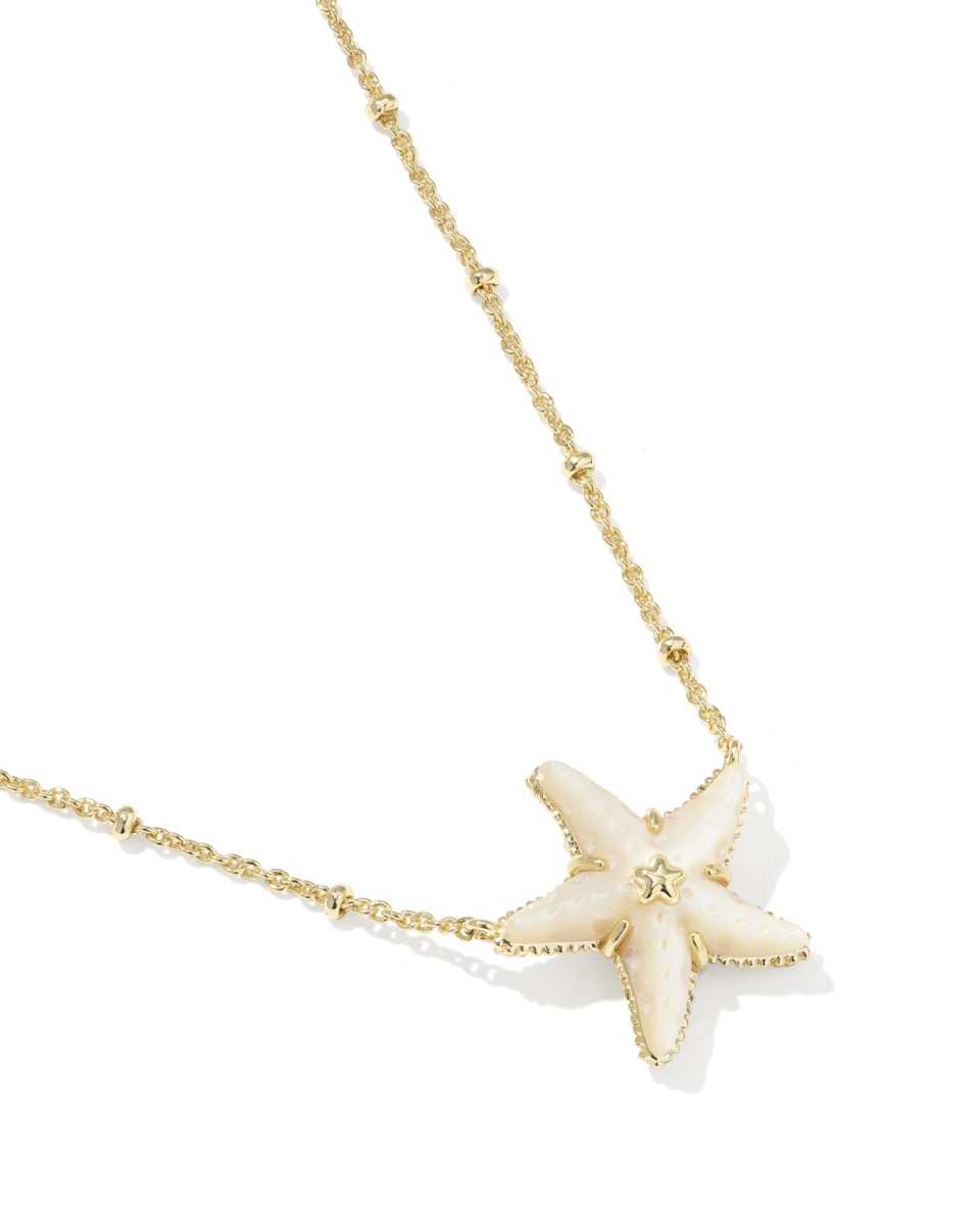 Starfish pendant necklace on a gold chain against a white background