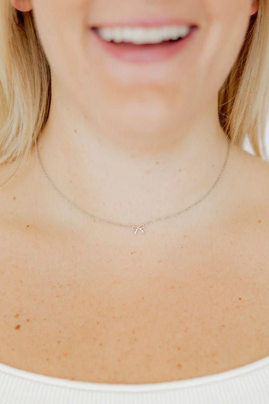 BOUTIQUE LINNY CO SADIE BOW SILVER BOW NECKLACE ON NECK