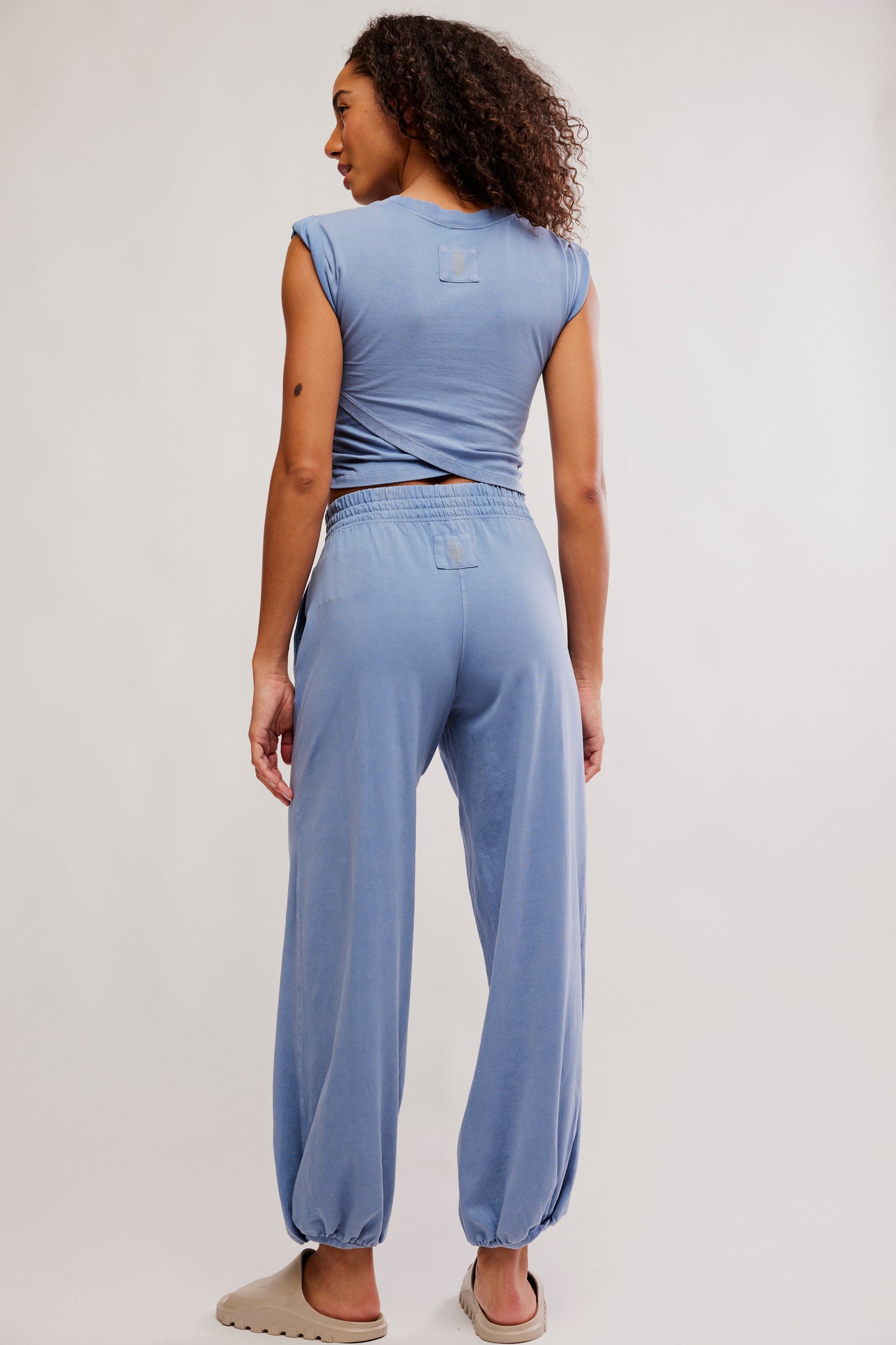 Woman wearing a blue outfit with a plain background