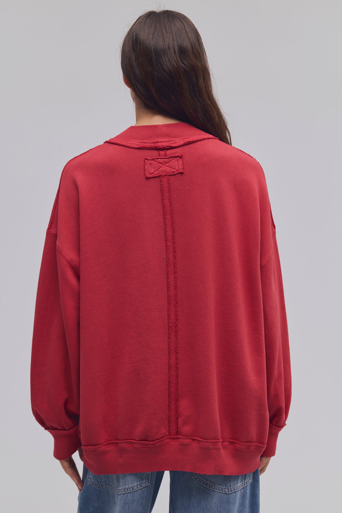 Person wearing a red sweatshirt with a plain background