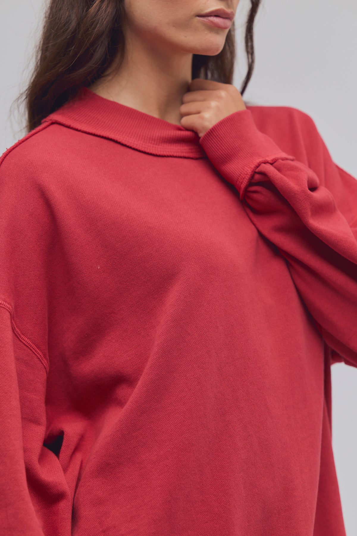 Red sweater worn by a person on a plain background