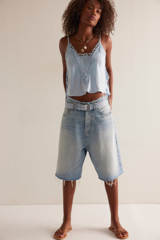 Woman wearing a light blue denim outfit against a plain background