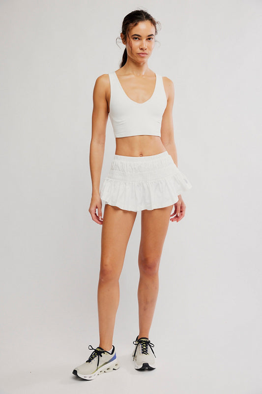 Woman wearing a white athletic outfit on a plain background