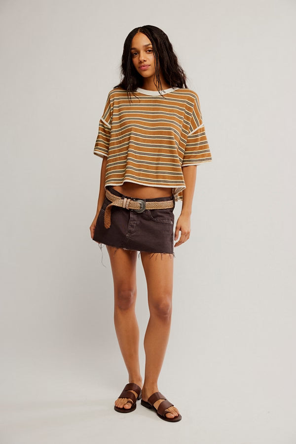 Woman wearing a striped shirt and shorts on a plain background