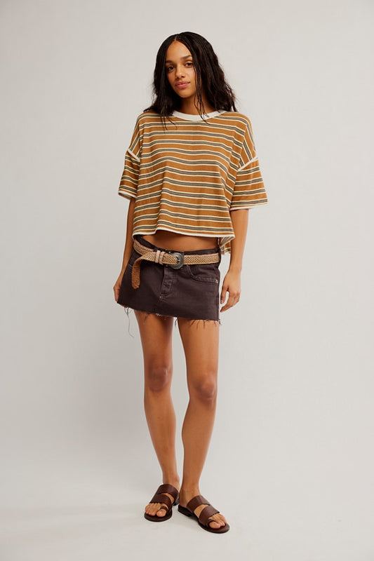Woman wearing a striped shirt and shorts on a plain background
