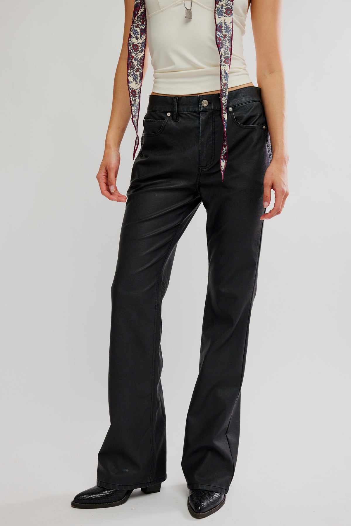 Person wearing black pants with a plain background