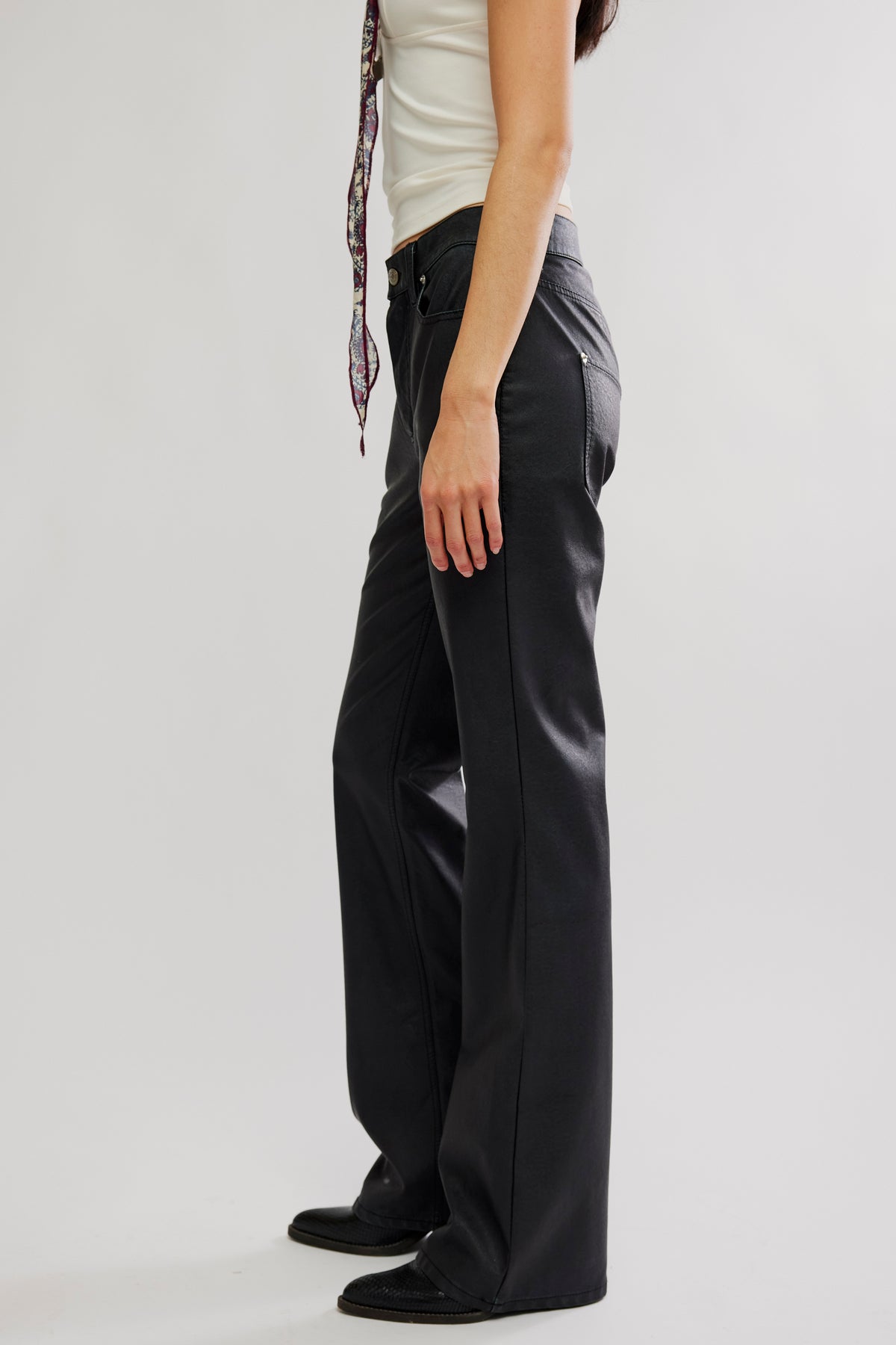 Person wearing black wide-leg pants on a plain background