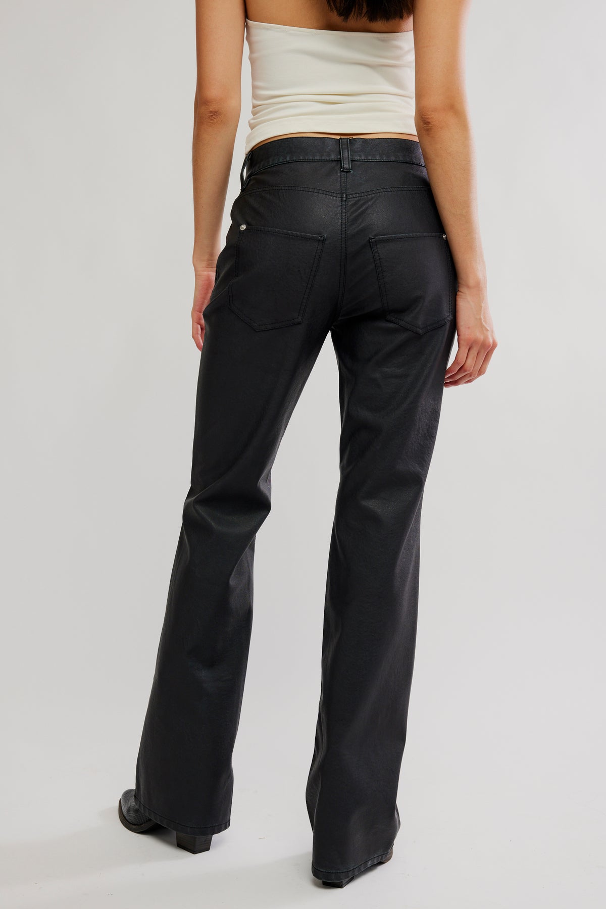 Person wearing black pants on a plain background