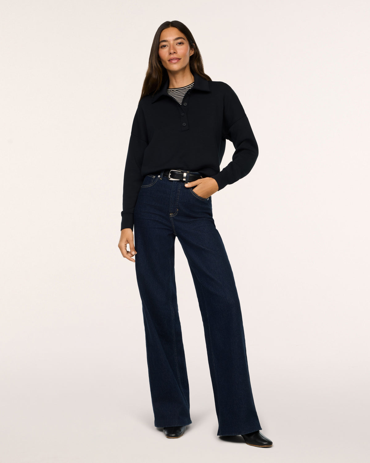 Model wearing SPANX Rugby Shirt in Very Black with jeans and white background.
