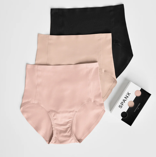 Three pairs of shapewear in black, beige, and pink with a Spanx packaging on a light gray background.