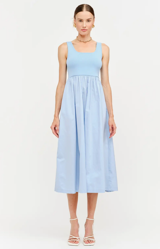 Woman wearing a light blue sleeveless dress on a white background